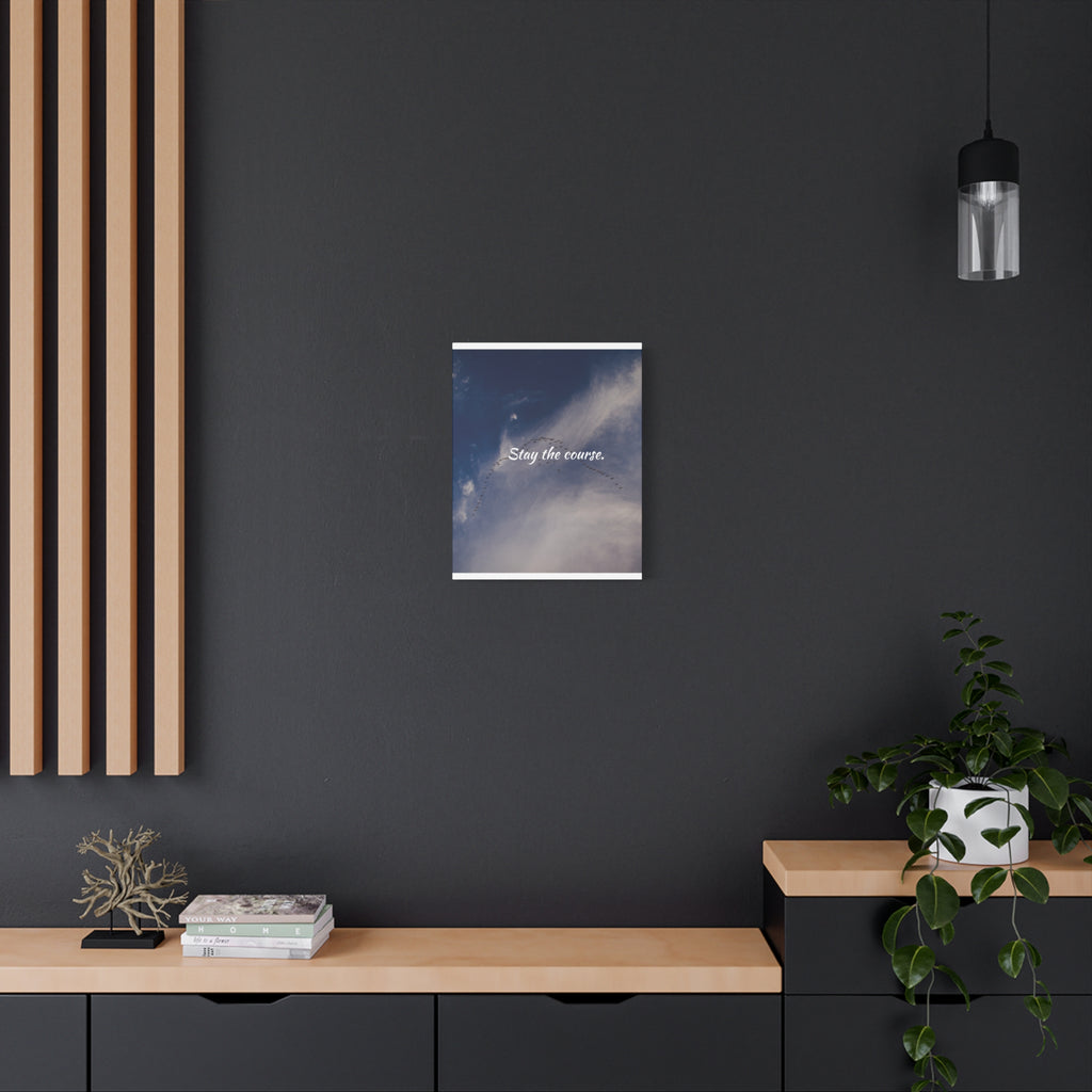 Poster with a blue sky design on a dark wall above a wooden shelf.