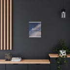Poster with a blue sky design on a dark wall above a wooden shelf.
