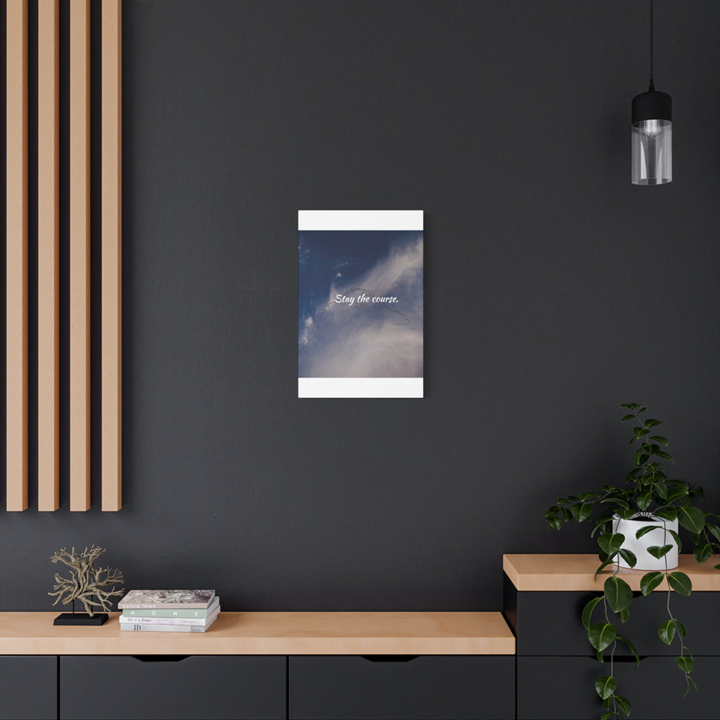 Poster with a blue sky and white cloud design on a dark wall above a wooden shelf.