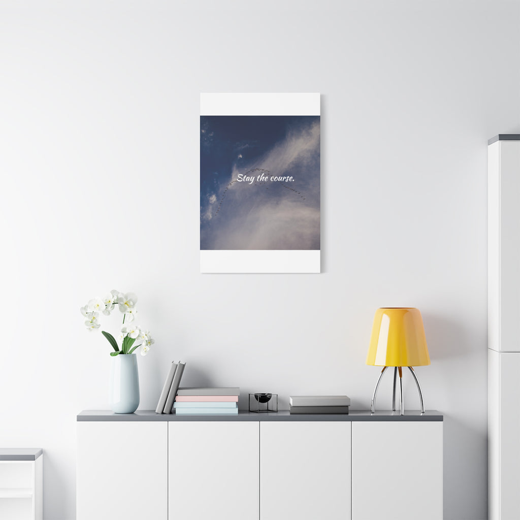 Framed artwork with motivational quote on a wall above a desk with decor items.