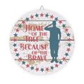 Decorative plate with a silhouette of a soldier and text 'Home of the Free Because of the Brave' on a wooden background.