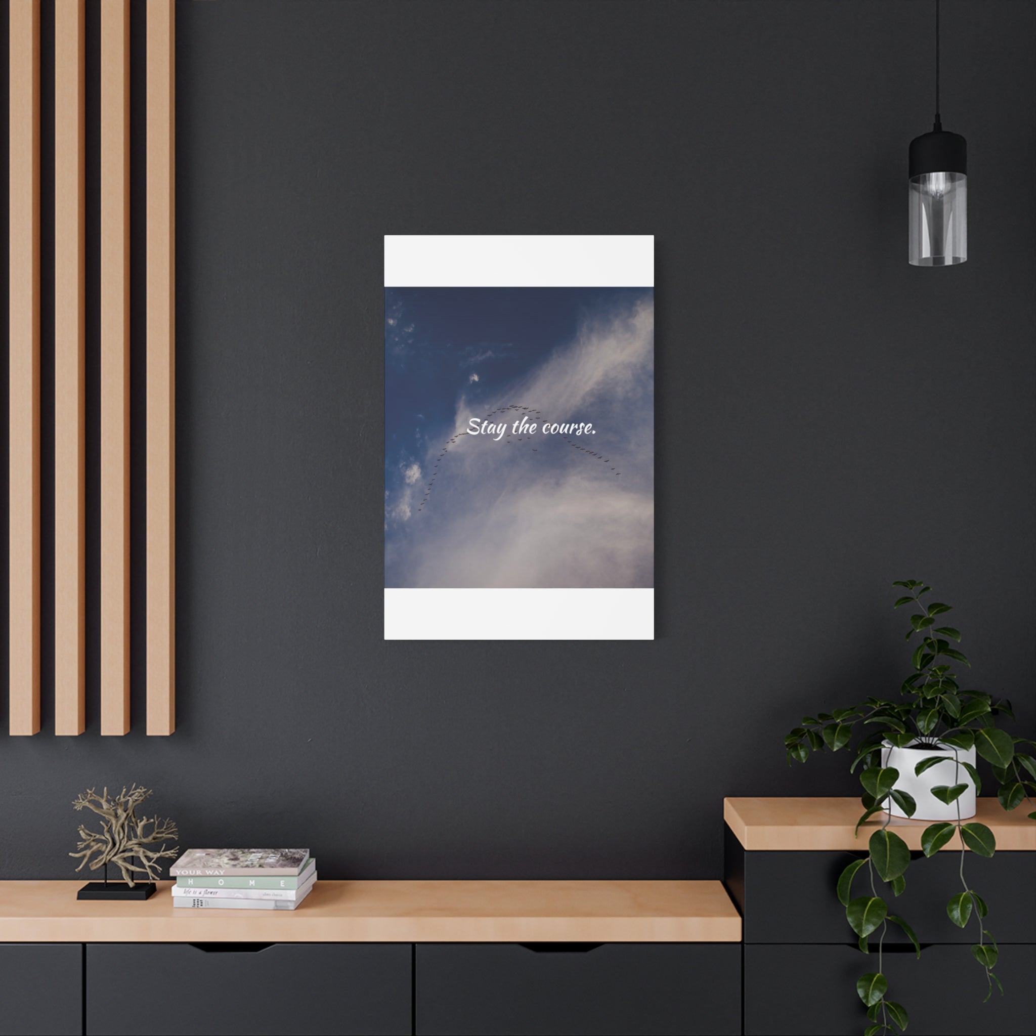 Poster with motivational quote 'Stay the course.' on a dark wall with decor elements.