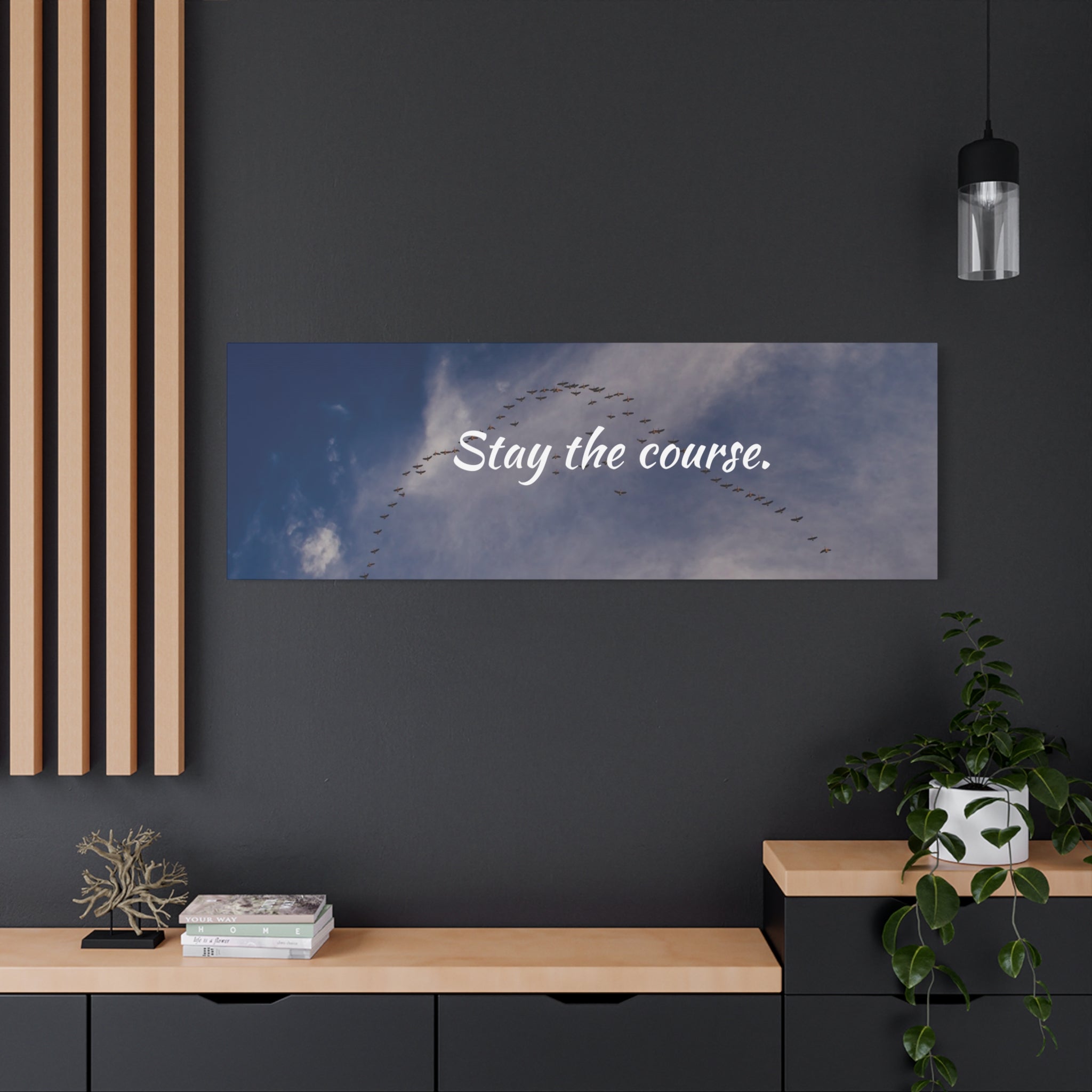 Wall art with 'Stay the course.' text above a dark wall with decor elements.