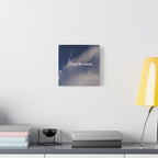 Framed artwork of a classical sculpture on a wall above a desk with books and a lamp.