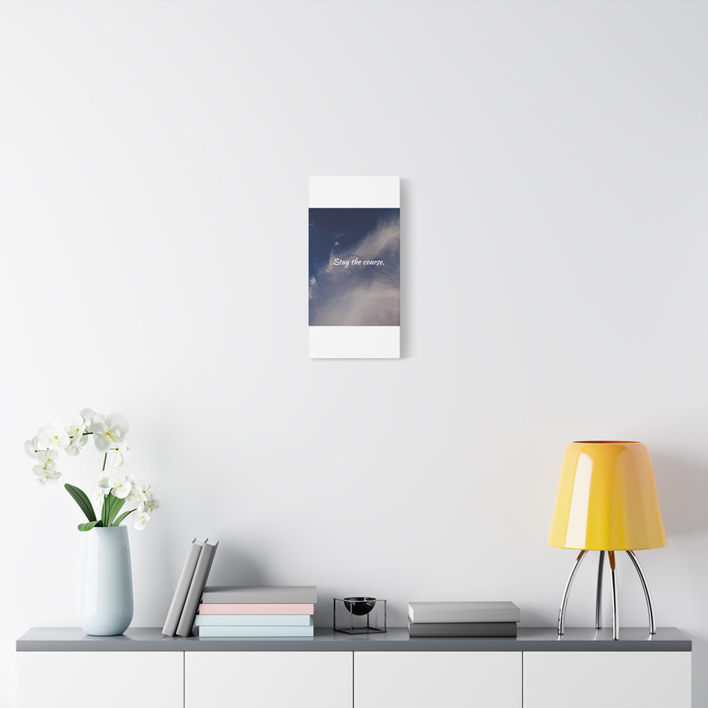 Framed artwork on a wall above a shelf with decor items.
