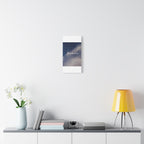 Framed artwork on a wall above a shelf with decor items.