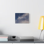Wall art with 'Stay the course.' text on a celestial background above a desk with books and a lamp.