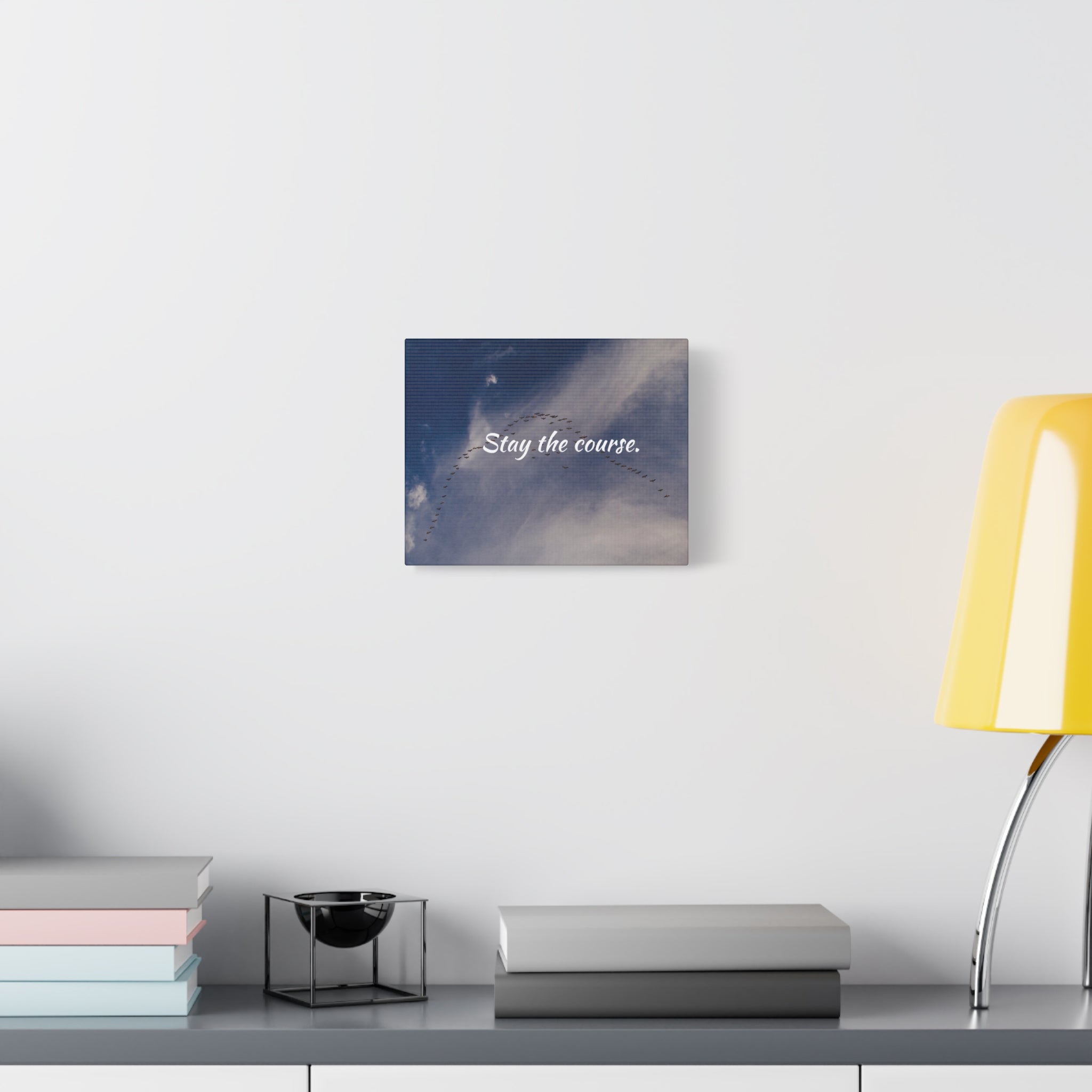 Decorative wall art with 'Stay the course.' text on a modern desk setup.