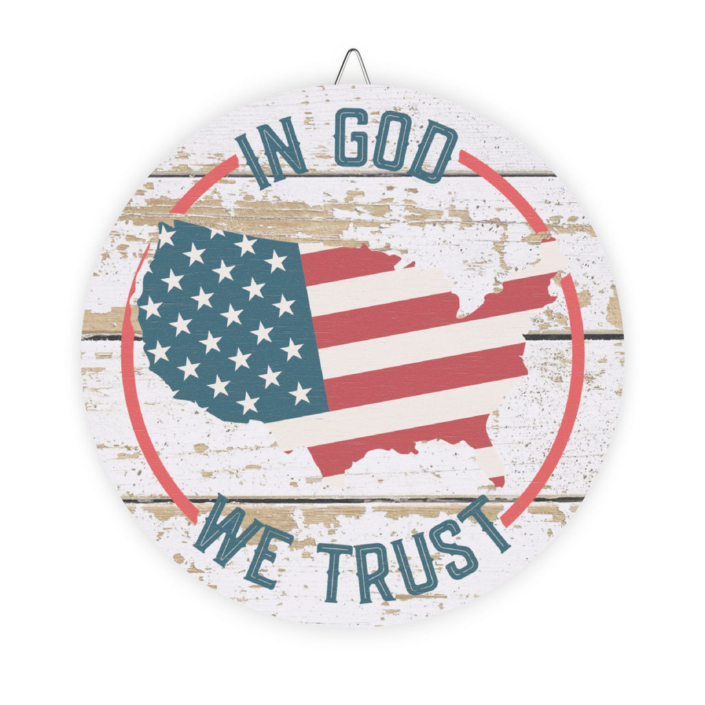 Decorative sign with American flag and 'In God We Trust' text on a wooden background