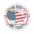 Decorative sign with American flag and 'In God We Trust' text on a wooden background