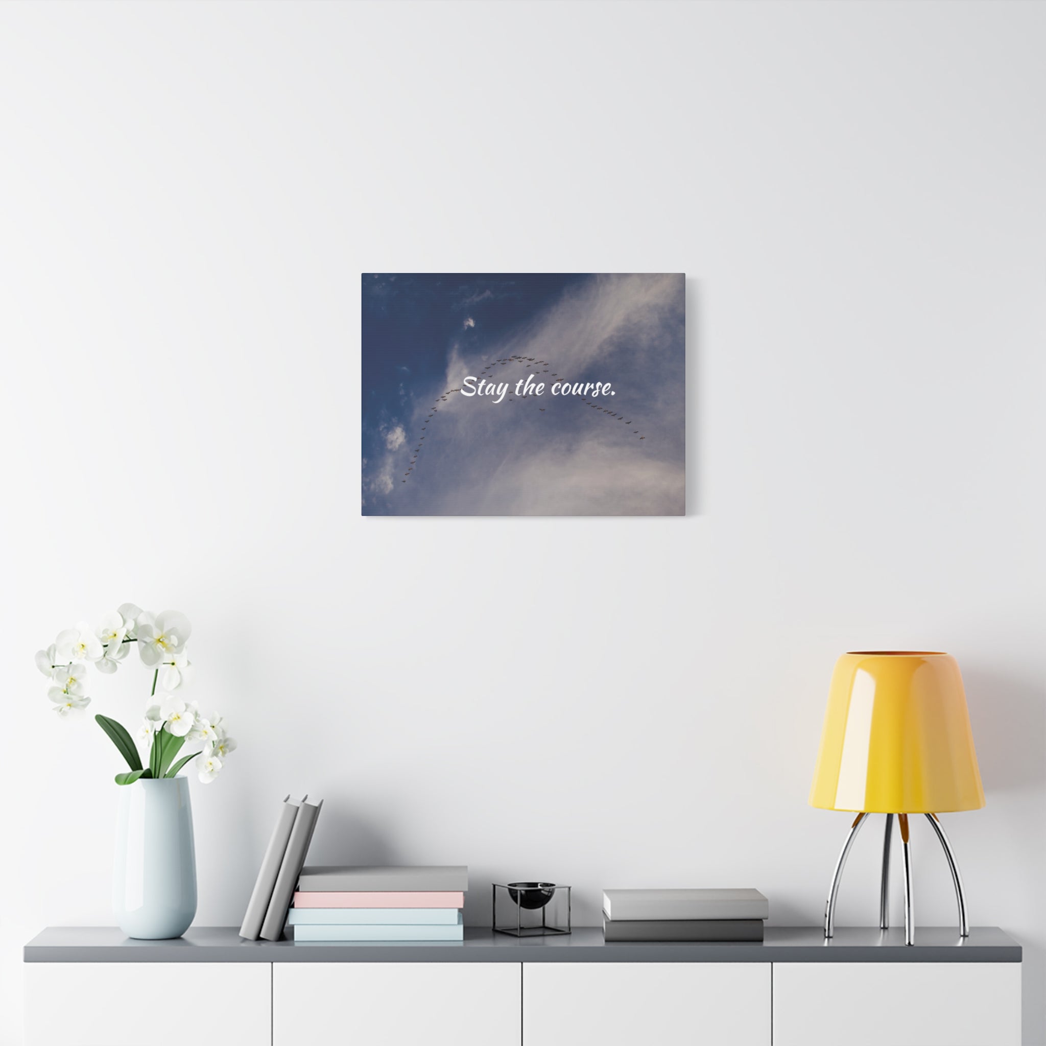 Wall art with 'Stay the course' text above a shelf with decor items.