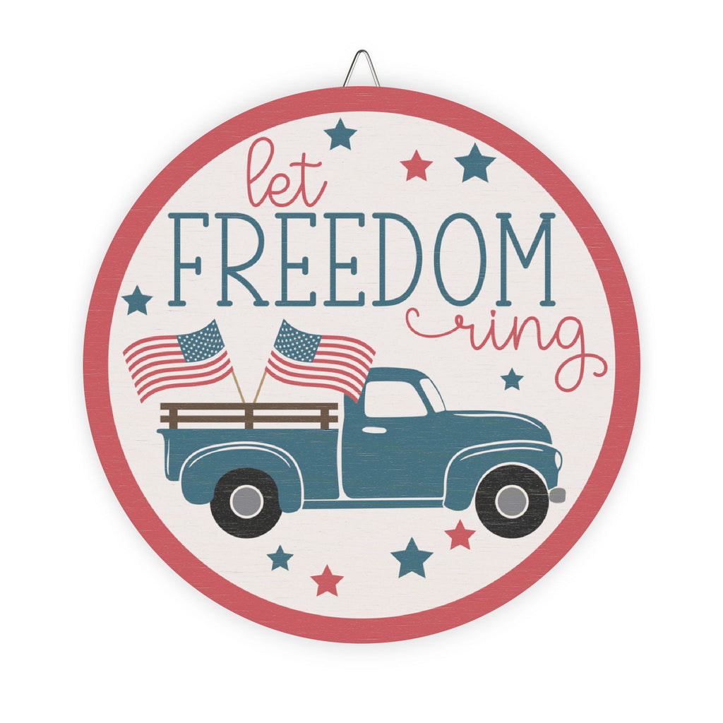 Decorative sign with a blue truck, American flags, and 'Let Freedom Ring' text on a white background.