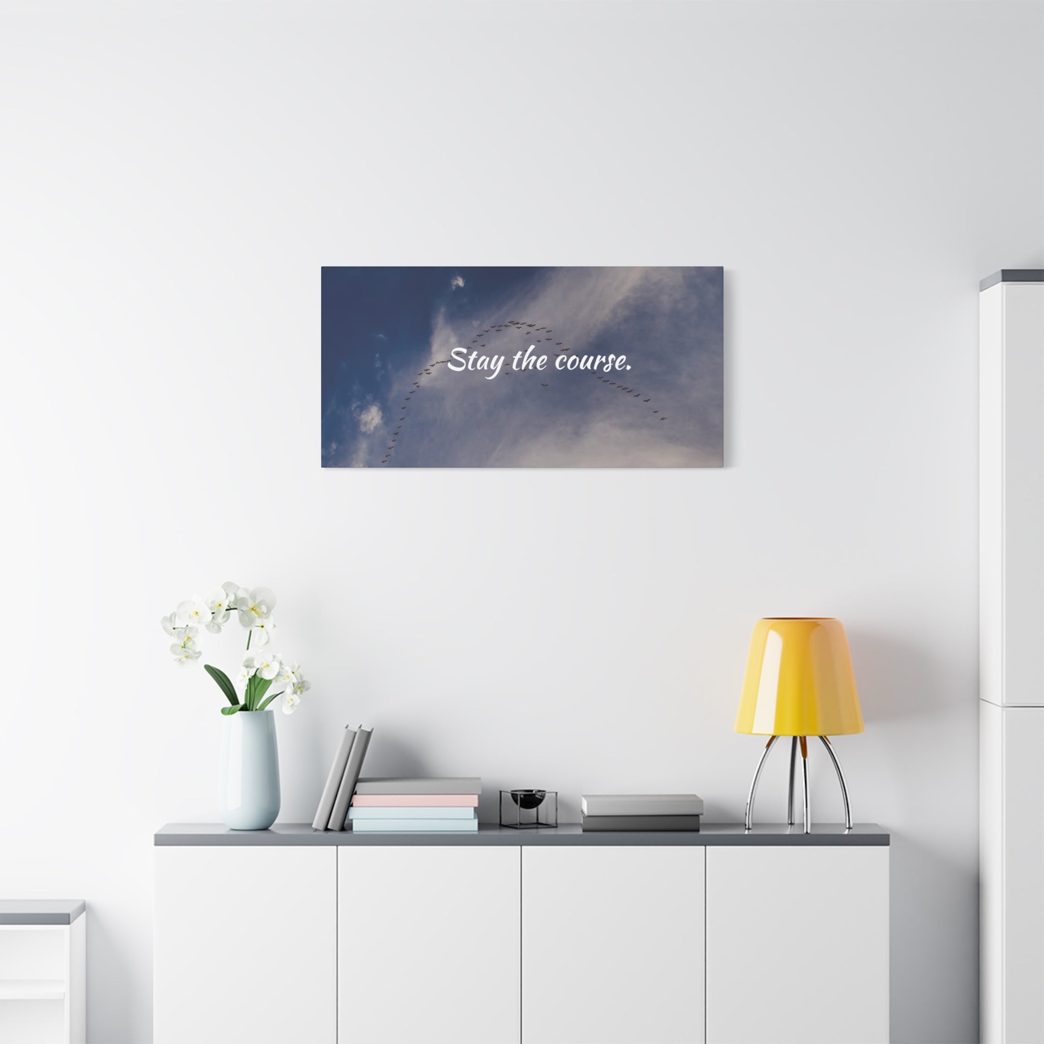 Wall art with 'Stay the course.' text in a modern office setting.