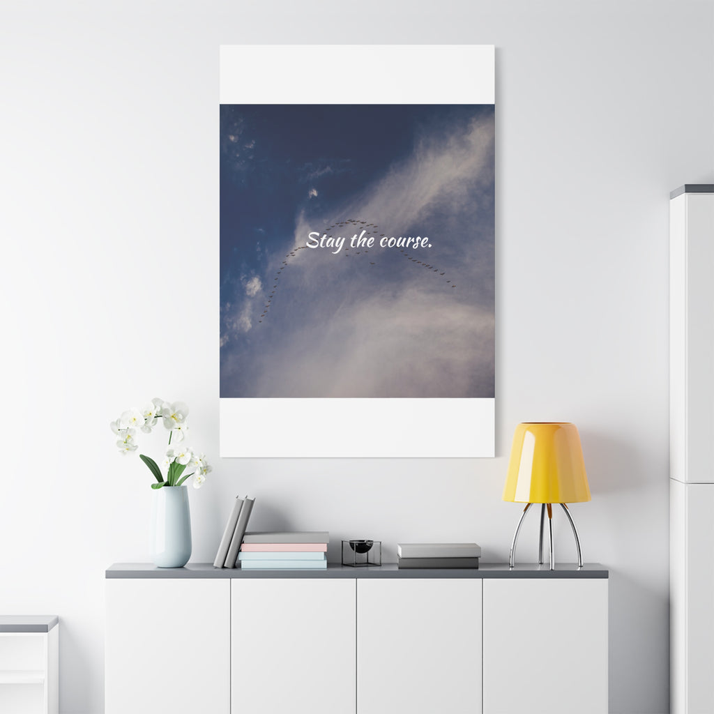 Poster with 'Stay the course.' text on a wall above a desk with decor items.