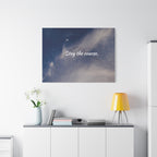 Wall art with 'Stay the course.' text above a white cabinet with decor items.
