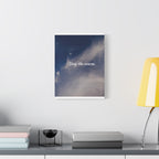 Framed artwork with 'Stay the course.' text on a wall above a desk with books and a lamp.
