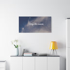 Wall art with 'Stay the course.' text above a white cabinet with decorative items.