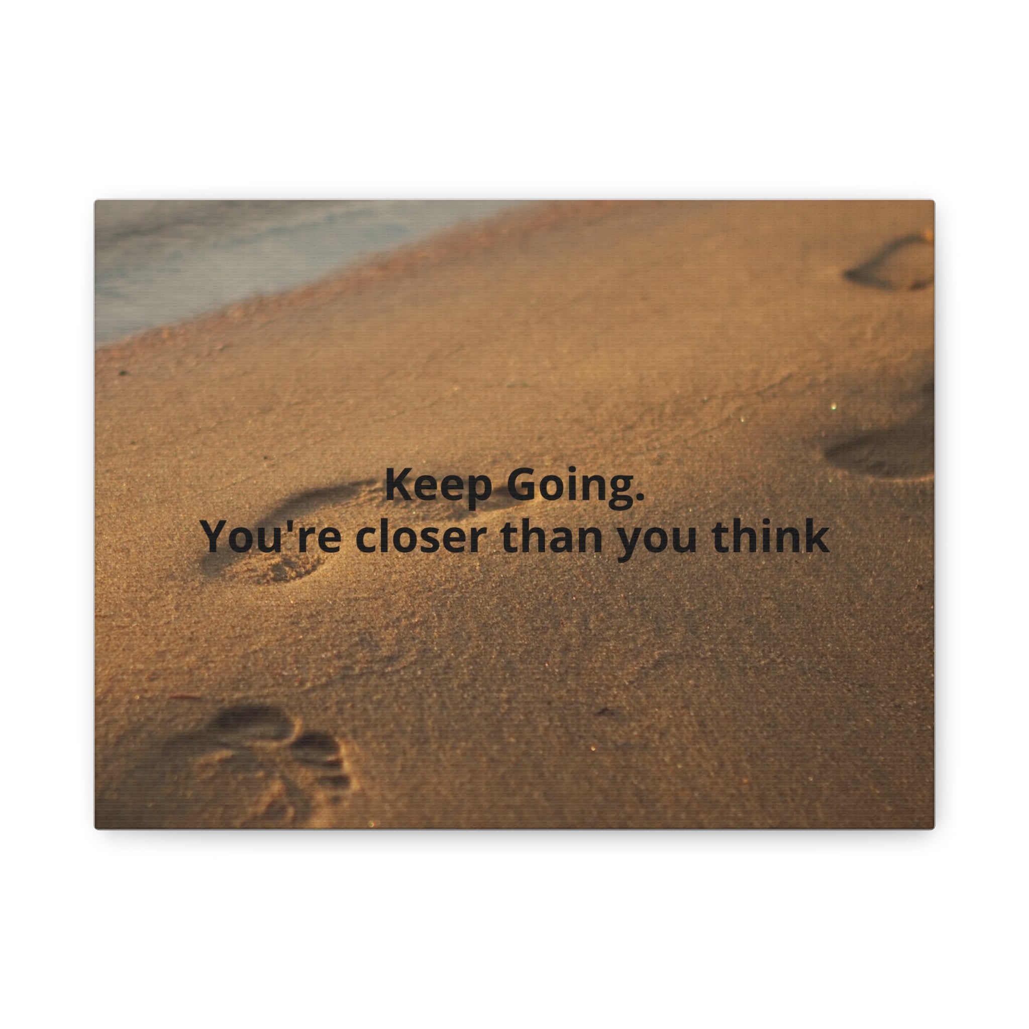 Footprints in sand with motivational quote 'Keep Going. You're closer than you think' on a white background