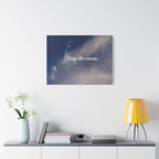 Wall art with 'Stay the course' text above a shelf with decor items on a white wall.