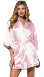 Woman wearing a light pink satin robe on a white background