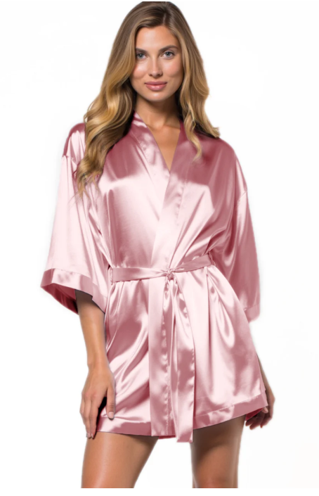Woman wearing a pink satin robe on a white background