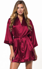 Woman wearing a wine red satin robe on a white background