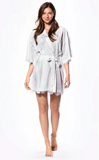Woman wearing a white satin robe on a white background