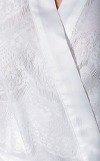 Close-up of a textured white garment with a V-neckline.
