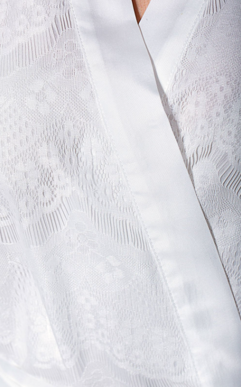Close-up of a textured white garment with a V-neckline.