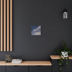 Small square painting on a dark wall above a wooden shelf with decorative items.