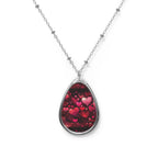 Teardrop-shaped pendant with heart design on a white background