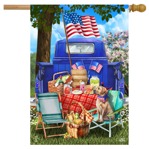 Decorative flag with a blue truck, American flags, and a picnic scene.