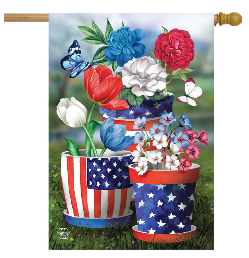 Decorative flag with American flag-themed flower pots and colorful flowers on a grassy background.
