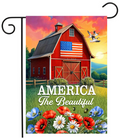 Decorative flag with a red barn, American flag, and 'America The Beautiful' text against a colorful sky.