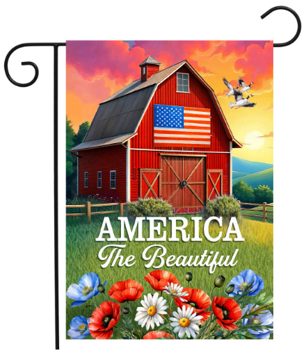 Decorative flag with a red barn, American flag, and 'America The Beautiful' text against a colorful sky.
