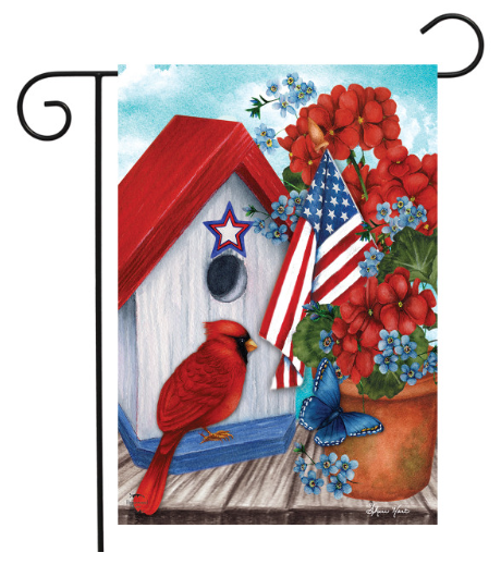 Decorative garden flag with a red birdhouse, cardinal, American flag, and flowers.