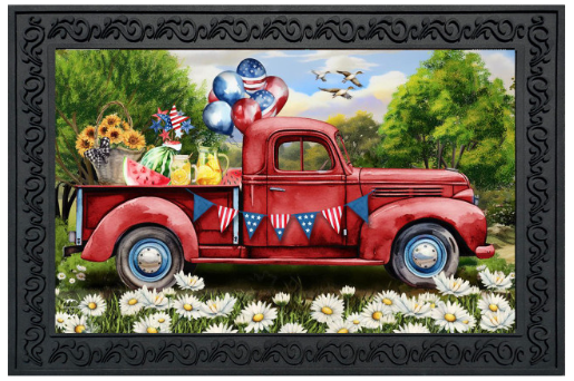 Vintage red truck with patriotic decorations in a scenic setting