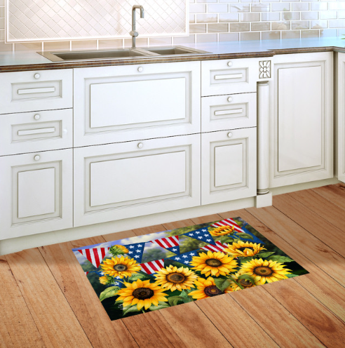 Decorative rug with sunflowers and American flags on a wooden floor in a kitchen.