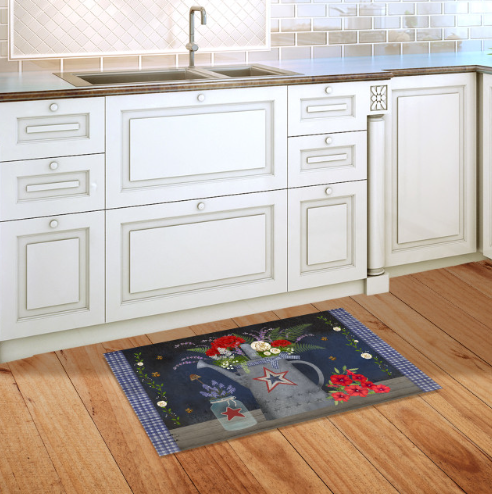 Decorative kitchen mat with floral design on a wooden floor in front of white cabinets.