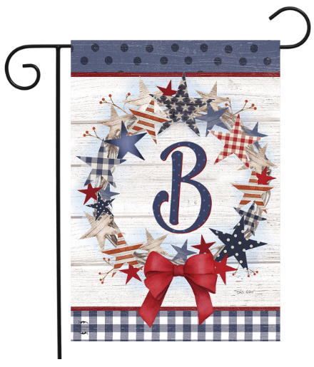 Decorative garden flag with stars, a bow, and the letter 'B' on a wooden background.