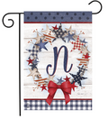 Decorative garden flag with stars, a bow, and the letter 'N' on a wooden background.