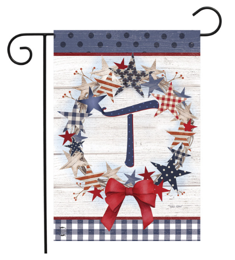 Decorative garden flag with stars, a bow, and plaid patterns on a white background.
