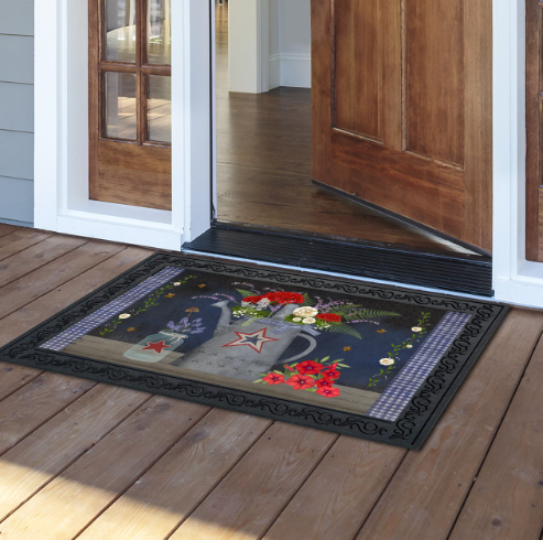Decorative doormat with floral and star design on a wooden deck.