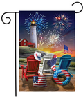 Decorative flag with a lighthouse, chairs, and American flags against a fireworks backdrop.