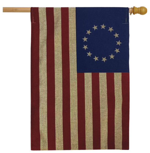Flag with red and white stripes and blue canton with white stars on a wooden pole.