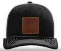 Black cap with a brown leather patch on a white background