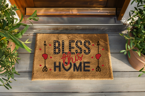 Doormat with 'Bless this Home' text on a wooden floor