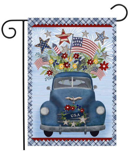 Decorative flag with a blue vintage car, American flags, and flowers on a checkered background.