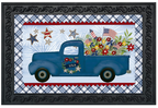 Decorative mat with a blue truck, American flags, and flowers on a plaid background.