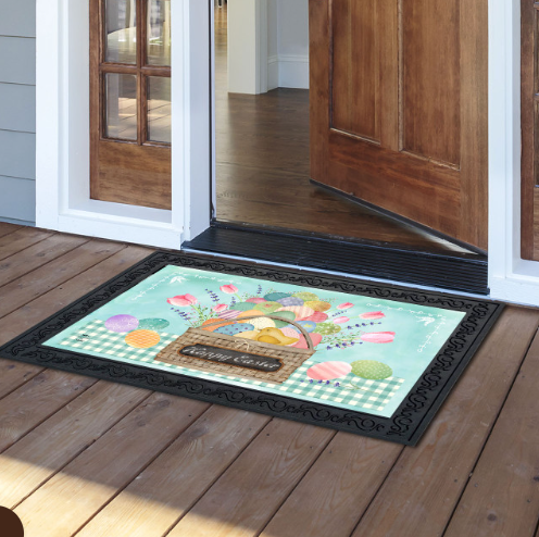 Decorative doormat with a basket of flowers design on a wooden floor.
